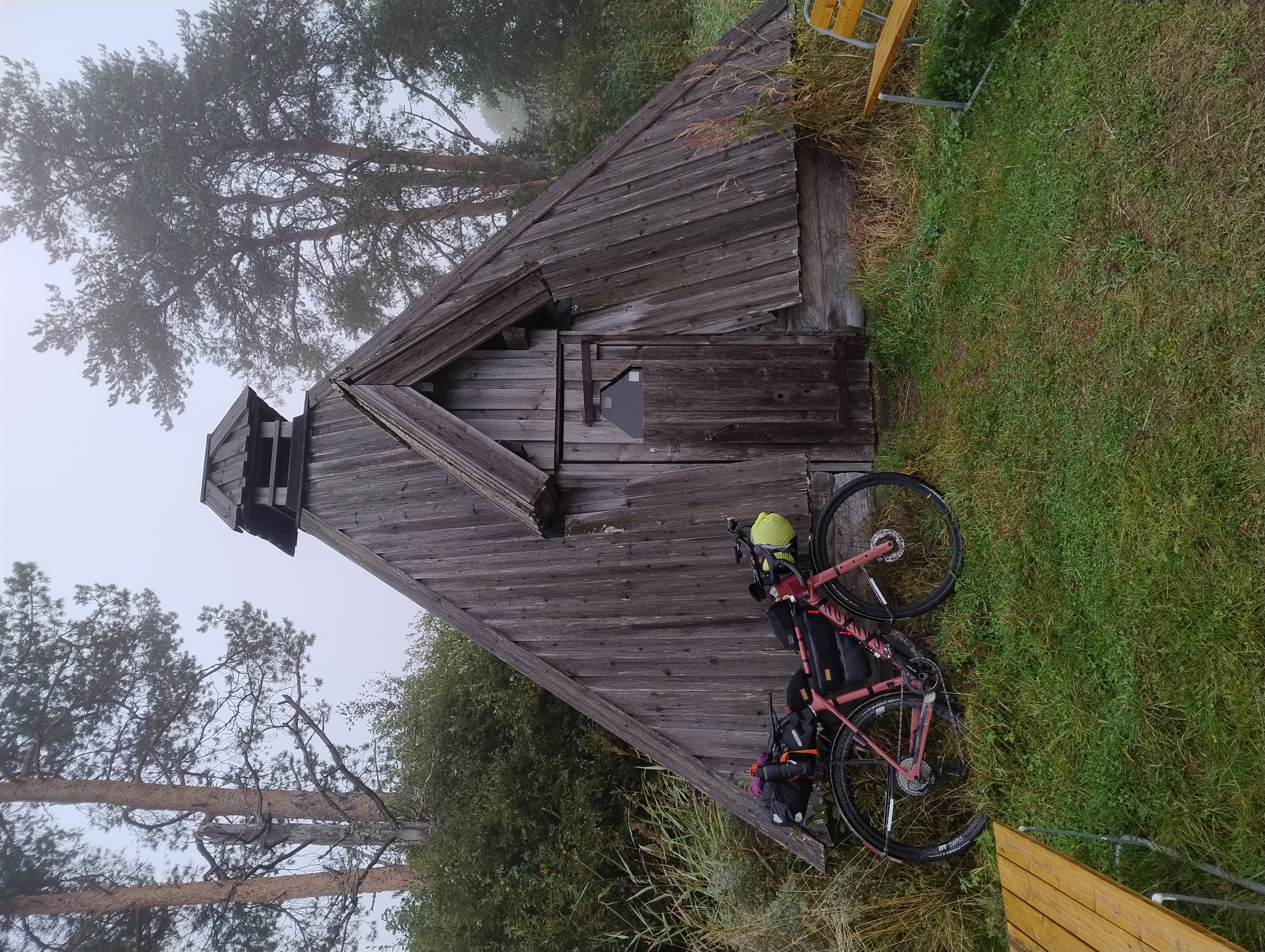 Polkupyörä nojaa ruskean kodan seinään