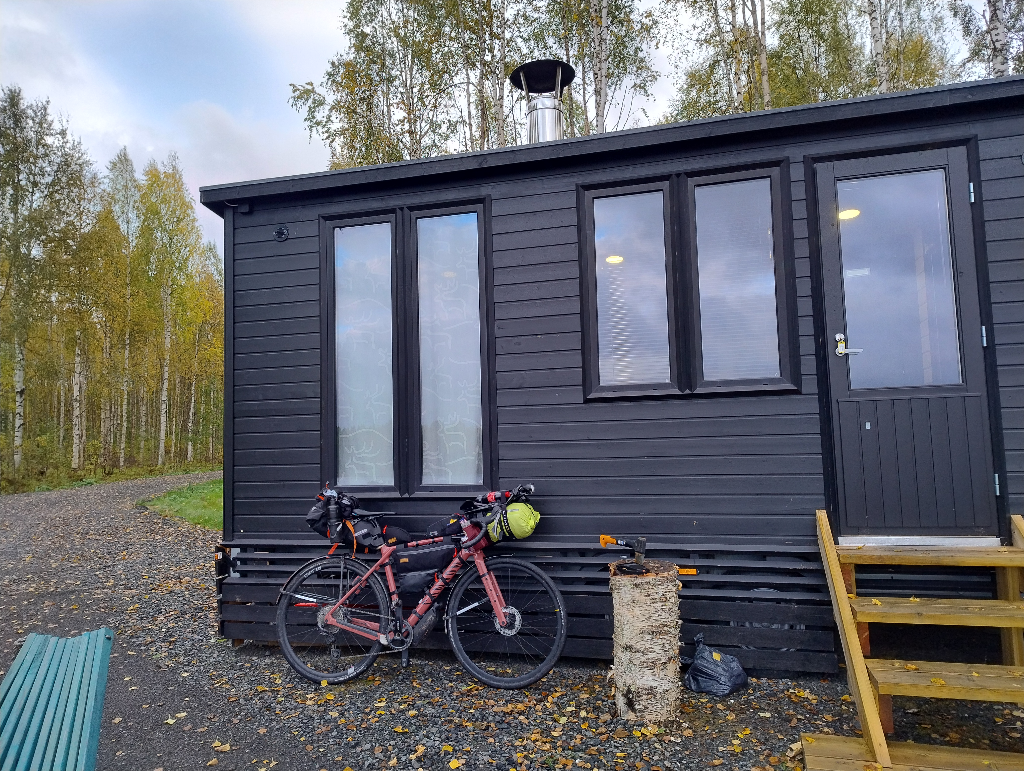 Polkupyörä tumman mökin edustalla